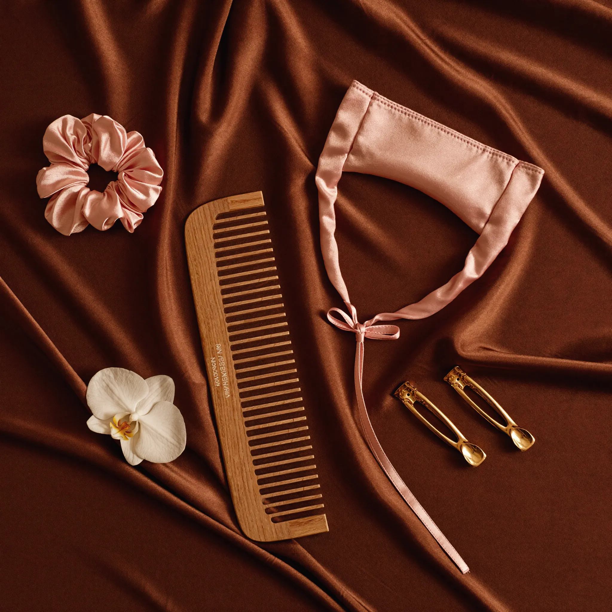 Productos para rizos sobre satén chocolate y rosa — Rizos Ondea